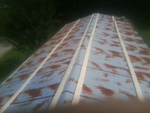Rusted metal roof panels with new wood purlins before replacement — Storm Damage Roof Repair in Ford Cliff by Roofing Brothers