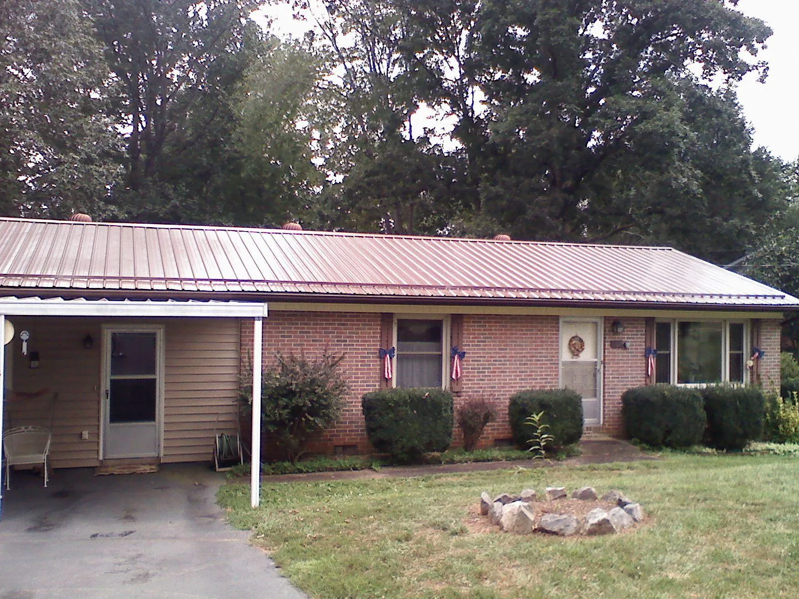 Bronze metal roof and carport on a brick ranch home — Roof Repair work by our crew in Ford Cliff