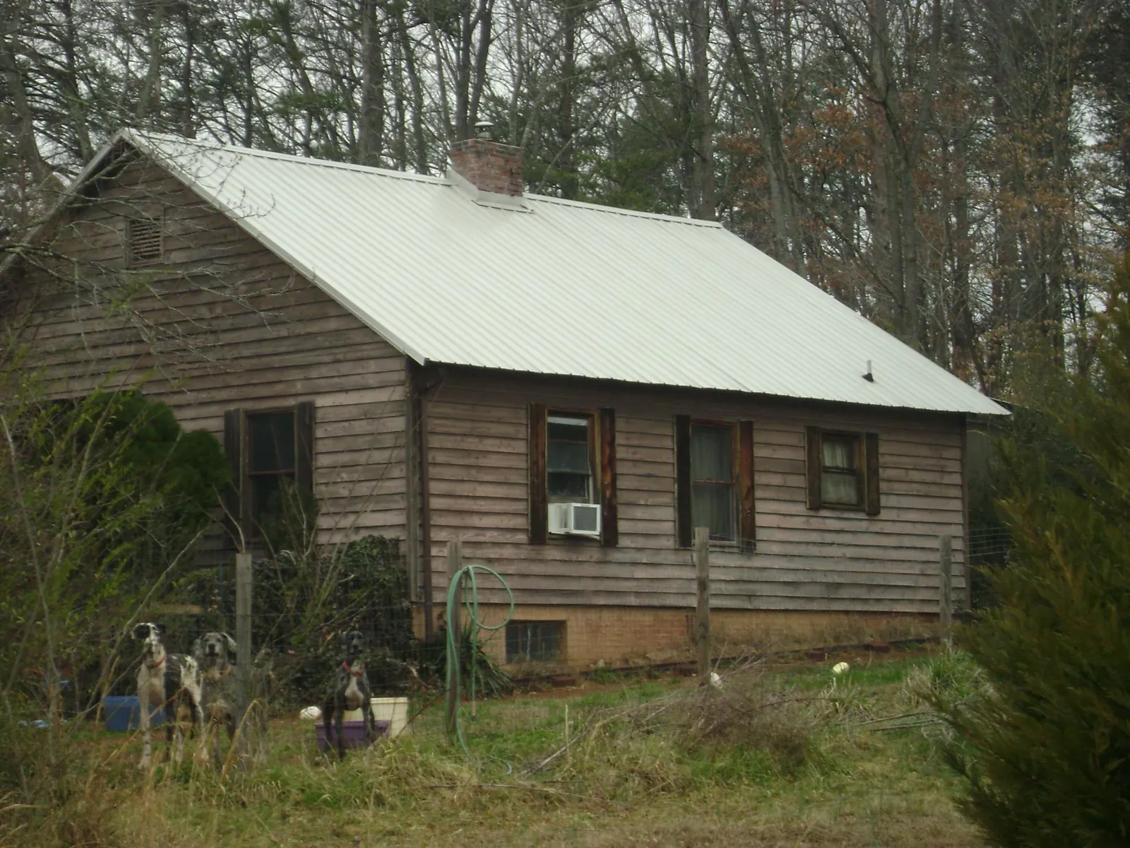 White metal roof on an old wood sided farmhouse, from a Metal Roof Installation job in Ford Cliff